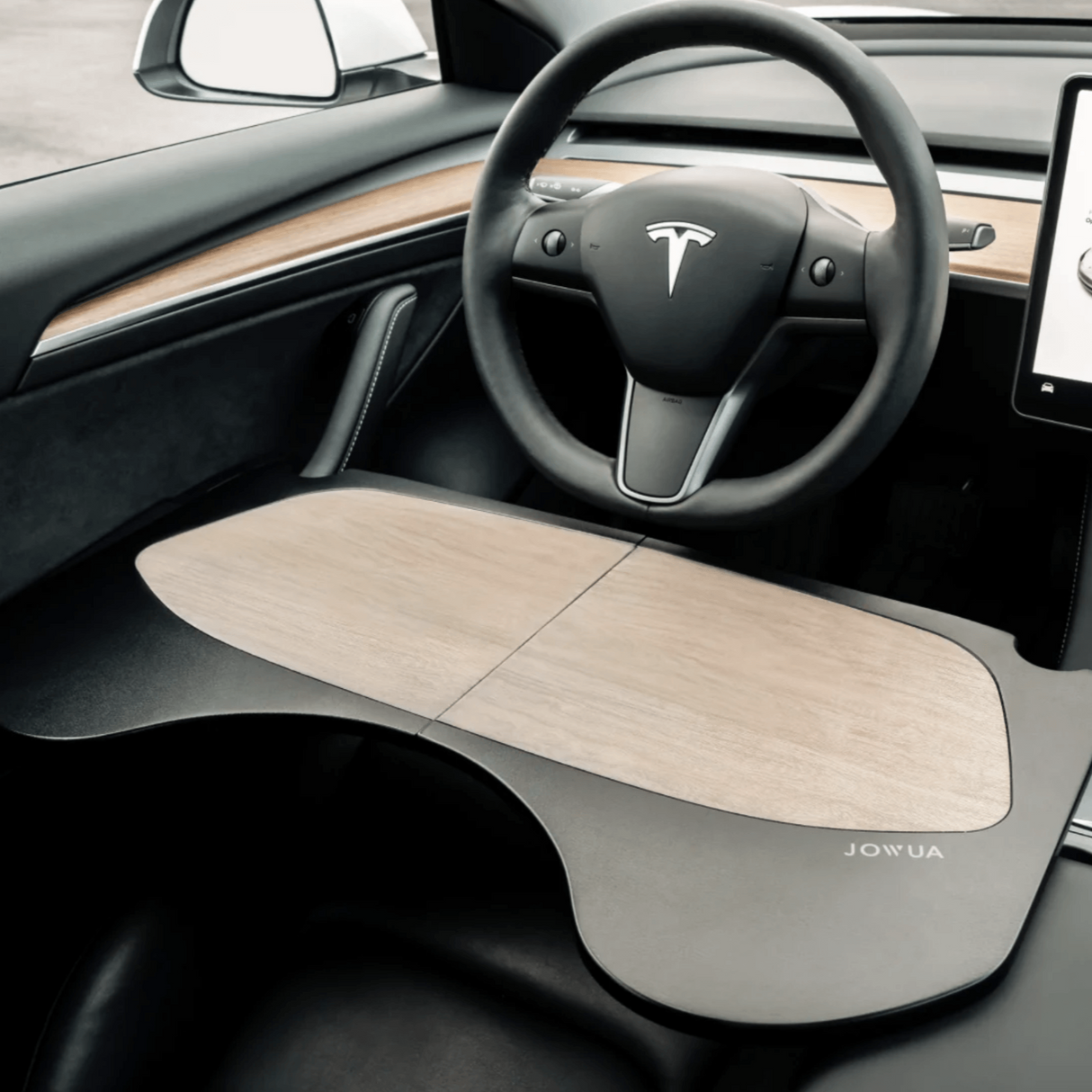 Hopfällbart bord med kolfiberlook i en Tesla Model 3-kabin.
