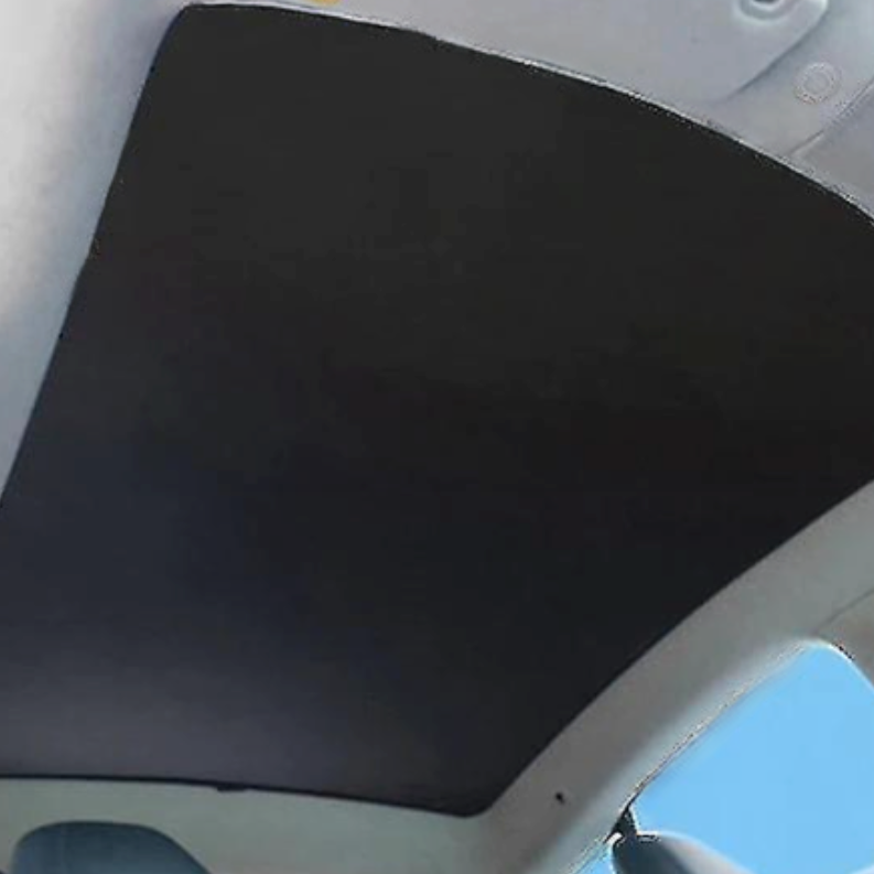 Sort solafskærmning monteret på panoramaglastaget i en Tesla Model S, set indefra