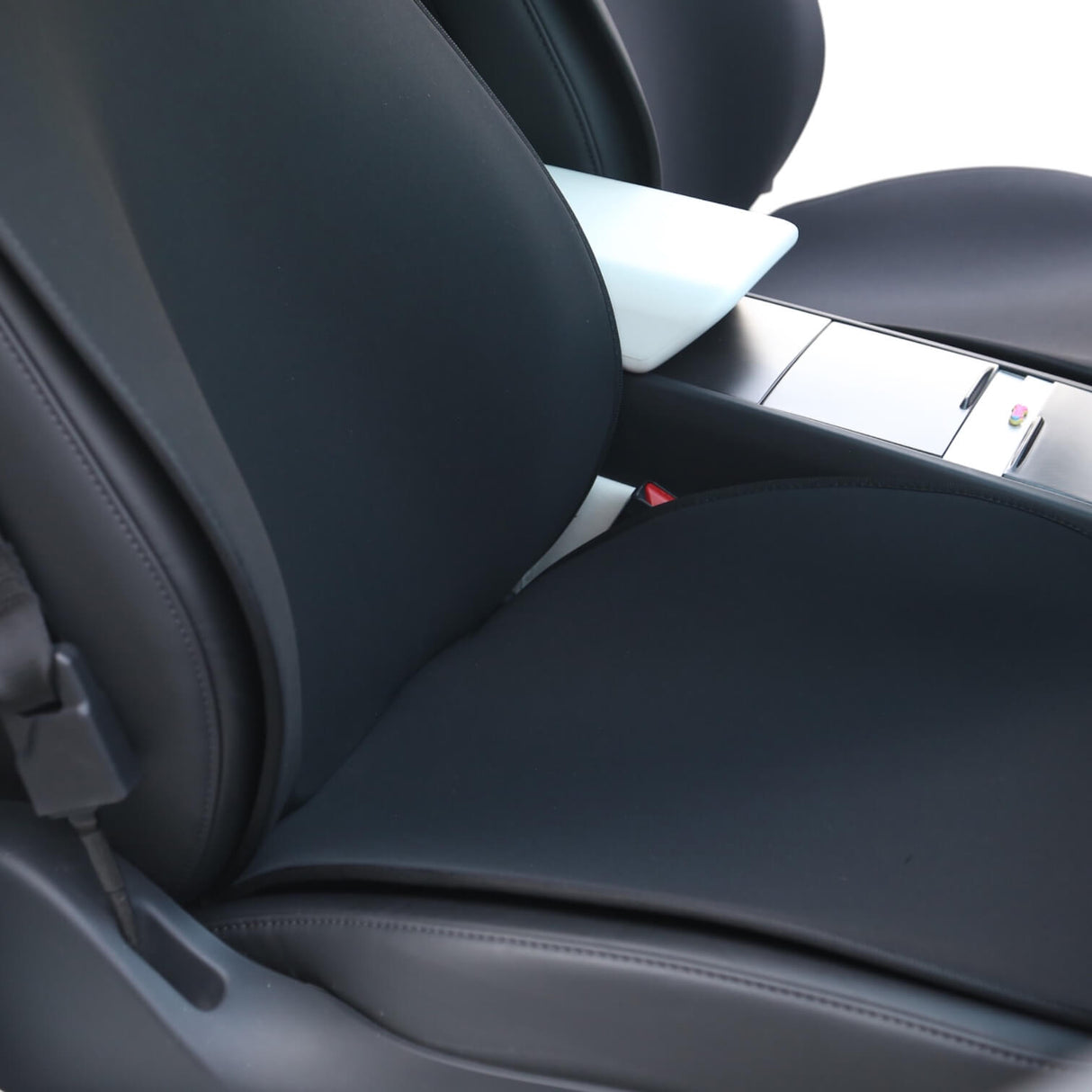 Svart sätesöverdrag monterat på framsätet i en Tesla Model 3 eller Model Y, sett på nära håll.