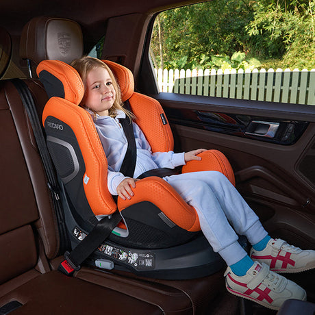 Lille pige sidder smilende i Recaro Xenon 1 Kid autostol i bilen