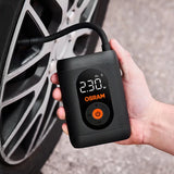 Hånd holder Osram TYREinflate 1600 og pumper bildæk, display viser 230 kPa