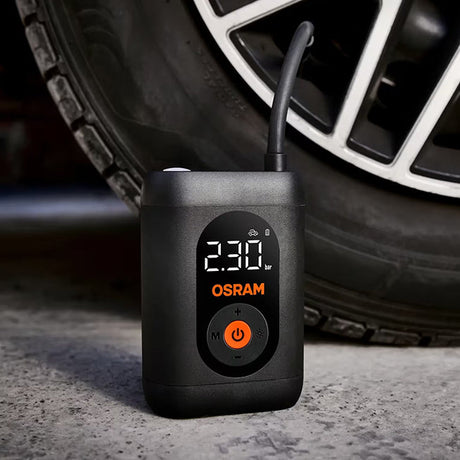 Osram TYREinflate 1600 stående på asfalt ved siden af bildæk, display viser 230 kPa