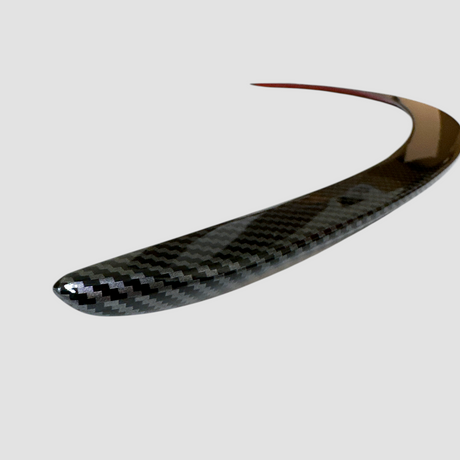 Detaljerad vy av blank carbon-look yta på Performance-spoiler för Model Y Juniper
