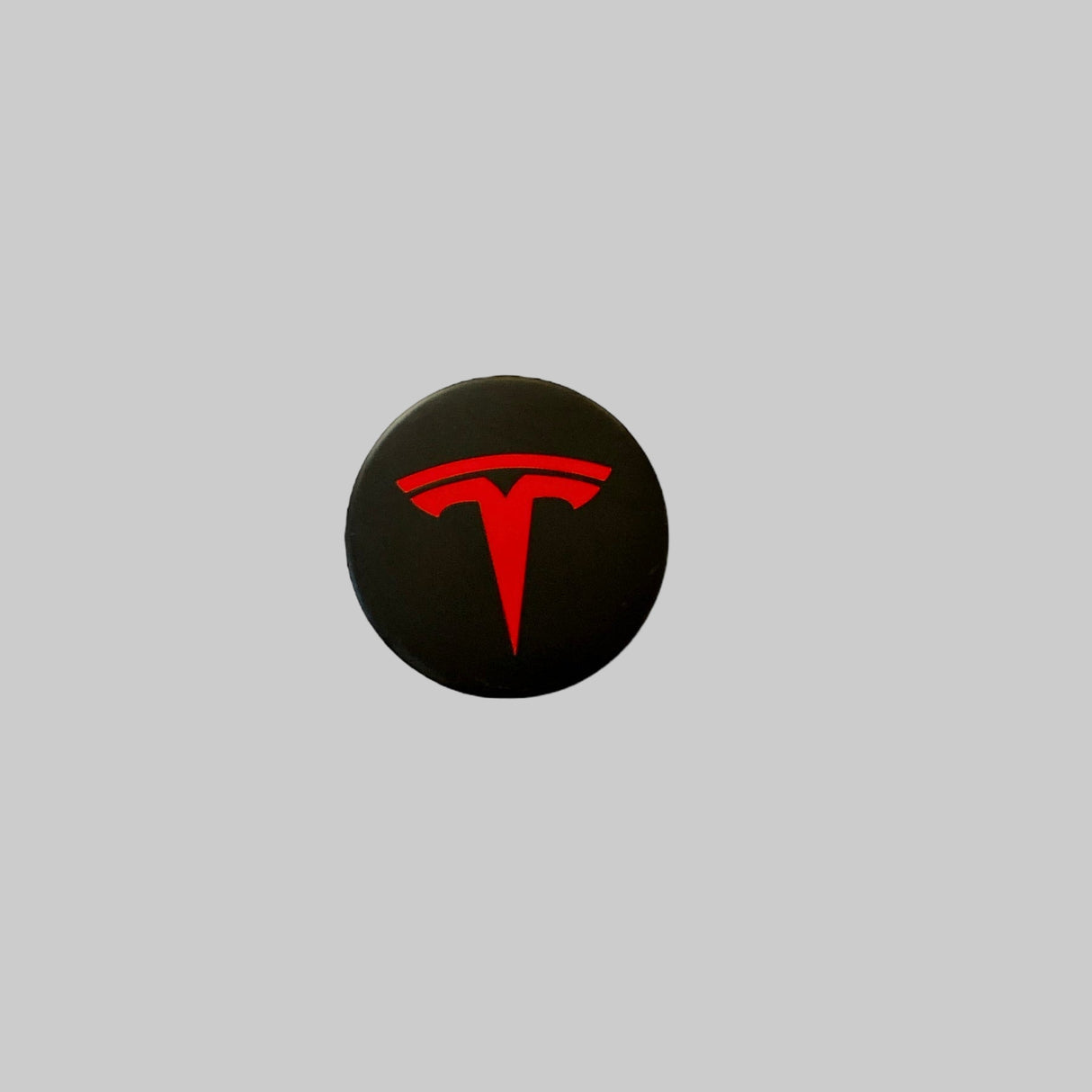 Röd navkapsel med Tesla-logotyp