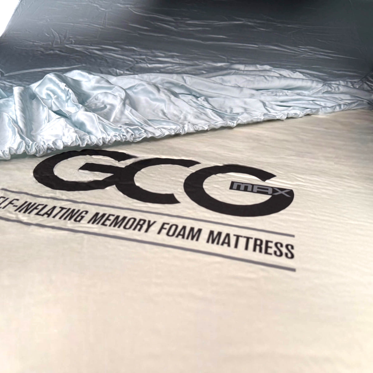 GCG MAX bambuslakan lagt över en madrass, med GCG MAX-logotyp.