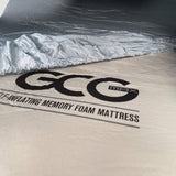 Bambuslakan från GCG MAX utlagt över en madrass med synligt GCG MAX-logotyp.