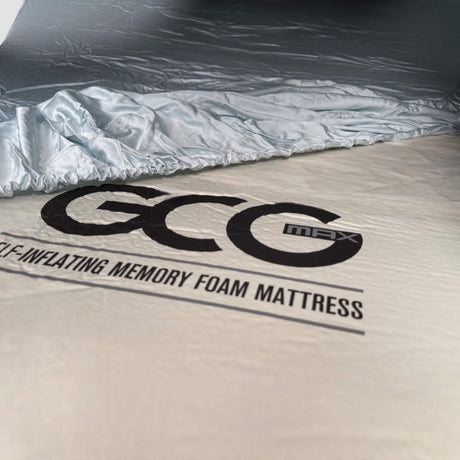 Bambuslakan från GCG MAX utlagt över en madrass med synligt GCG MAX-logotyp.