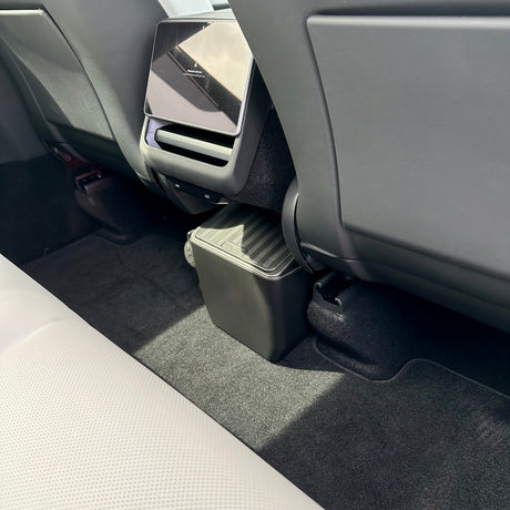 Avfallsförvaringsbox med klicklock, placerad vid baksätet i Tesla Model Y.