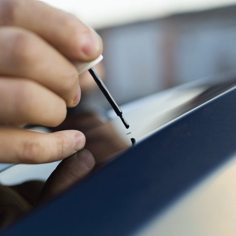 Lackstift som används för att göra ett repa i bilens lack