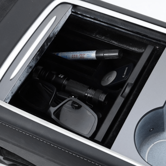 Förvaringsbox för Tesla Model 3/Y fylld med olika föremål.