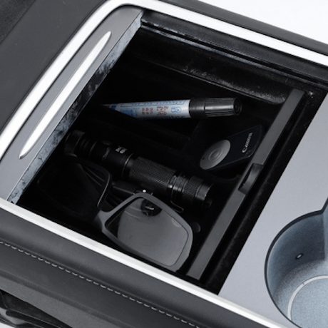 Förvaringsbox för Tesla Model 3/Y fylld med olika föremål.