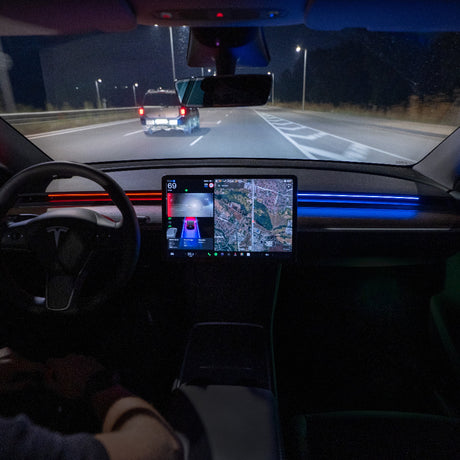 Ambientbelysning med S3XY Strip installerad i en Tesla Model 3/Y-kabin under körning på natten.