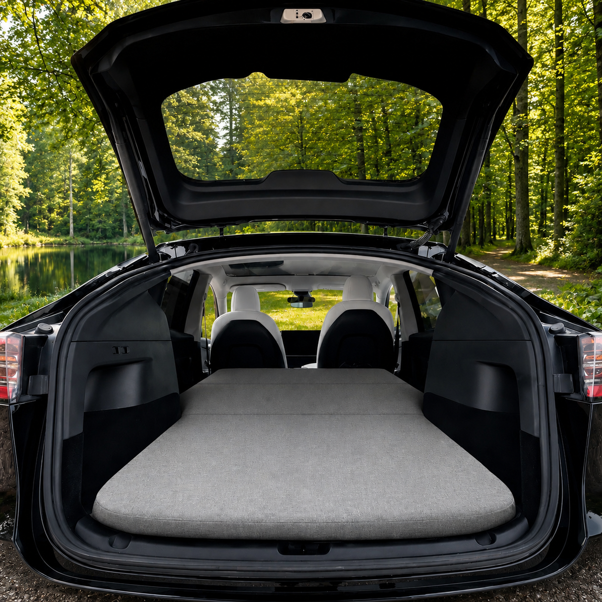 Skummadras ligger i bilen på en Tesla, med grøn skov i baggrunden