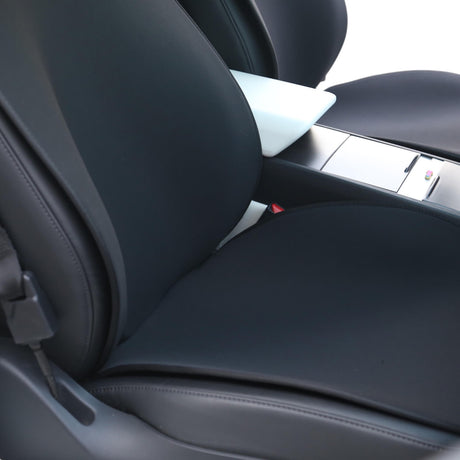 Svart sätesöverdrag monterat på framsätet i en Tesla Model 3 eller Model Y, sett på nära håll.