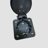 Närbild av svart V2L Type 2-adapter med öppet lock och 230V-uttag