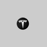 Navkapsel med vitt Tesla-logotyp
