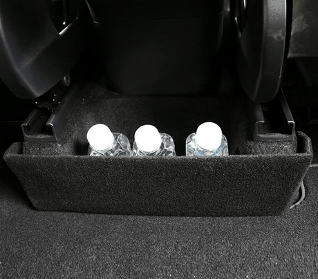 Delar för förvaring mellan säten i Tesla Model Y.